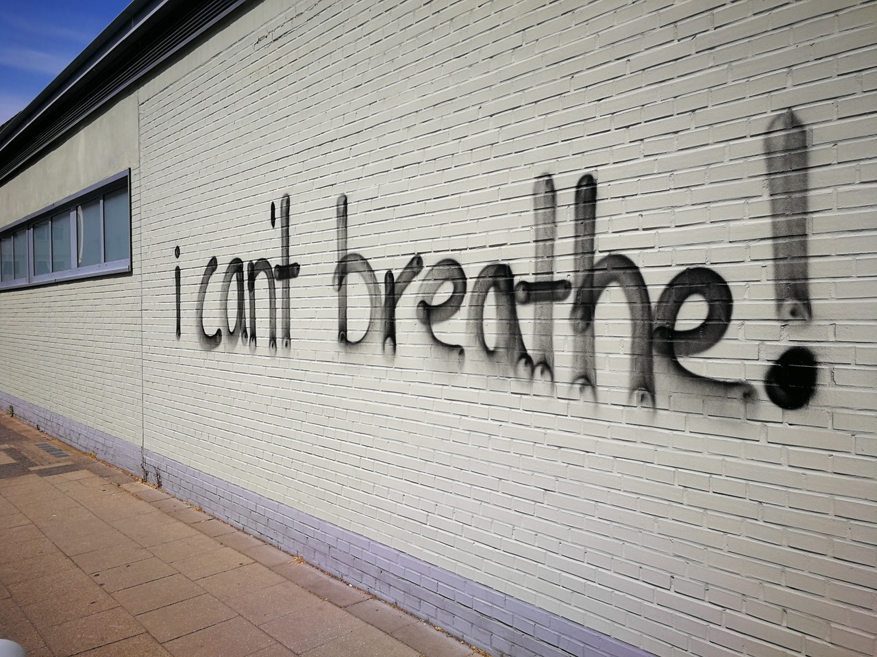 "I can't breathe!" painted on a white brick wall