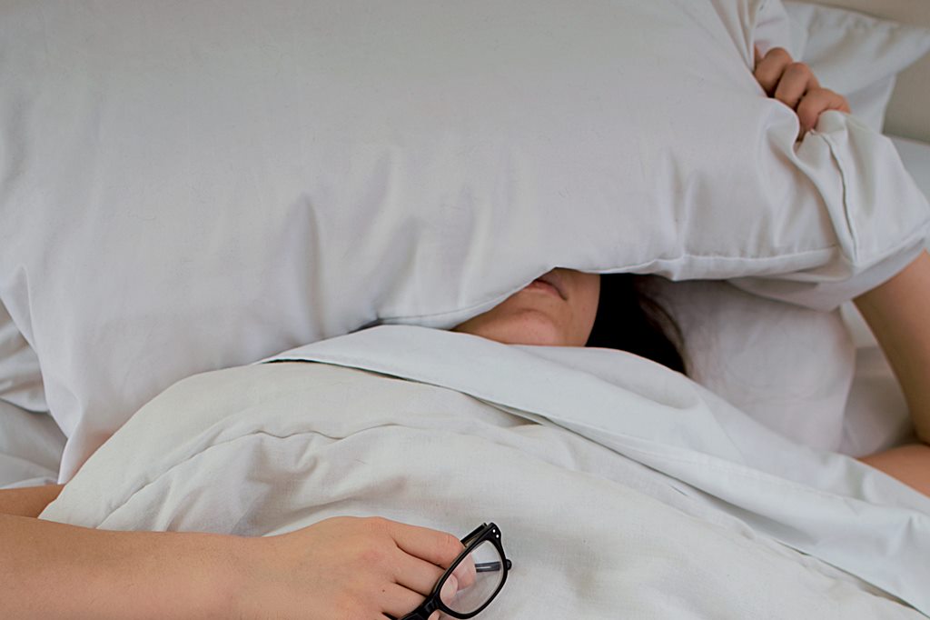 A person with pillow covering the face