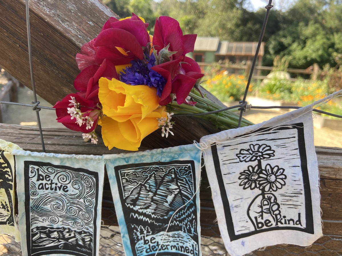 flowers on gate with prayer flags