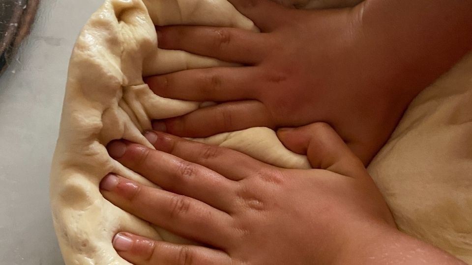 Kids hands kneeding dough